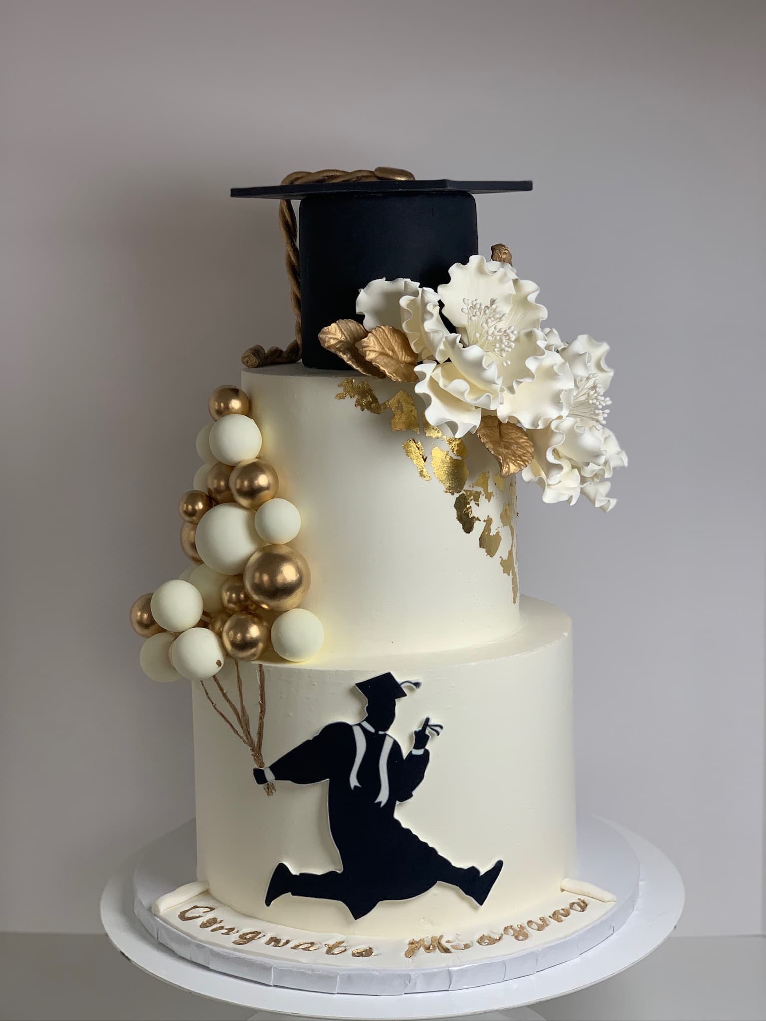 Black and gold graduation silhouette cake